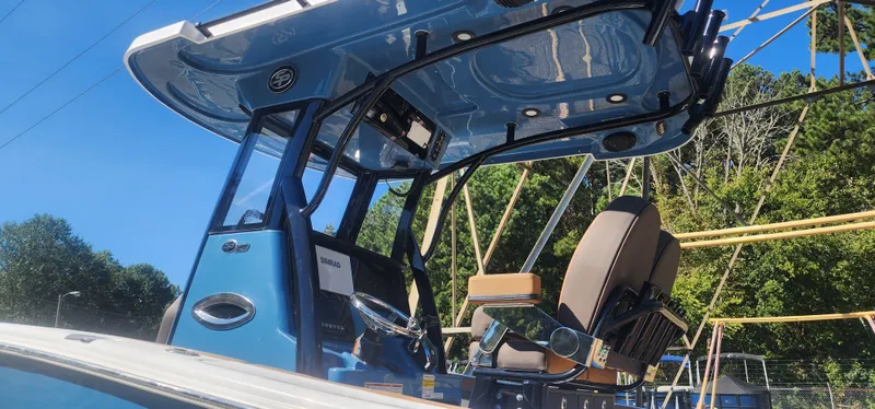 Slide: The Image of 2025 Sea Pro 242 DLX boat with blue console and seating, outdoors. - 3