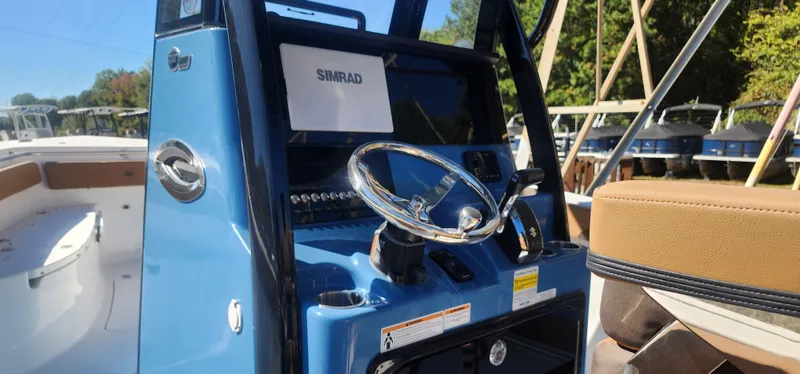 Slide: The Image of 2025 Sea Pro 242 DLX boat console with steering wheel and Simrad display. - 4