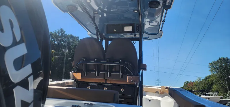 Slide: The Image of 2025 Sea Pro 242 DLX boat interior with seating and console under clear blue sky. - 5