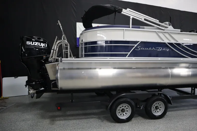 Slide: The Image of 2025 South Bay 222E pontoon boat with Suzuki outboard motor on trailer. - 2
