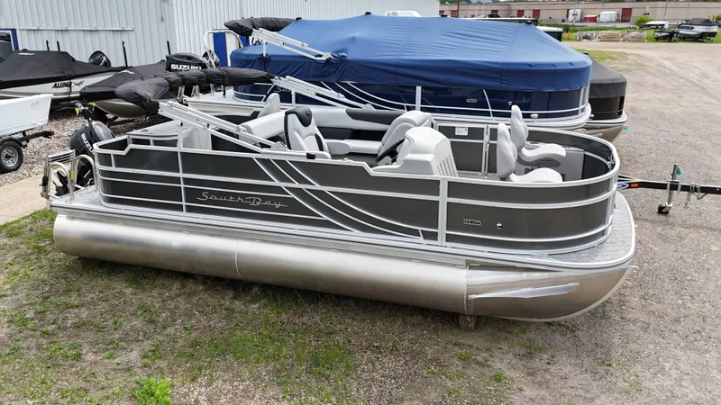 The Image of 2025 South Bay 220 F pontoon boat parked on gravel near other boats. - 0
