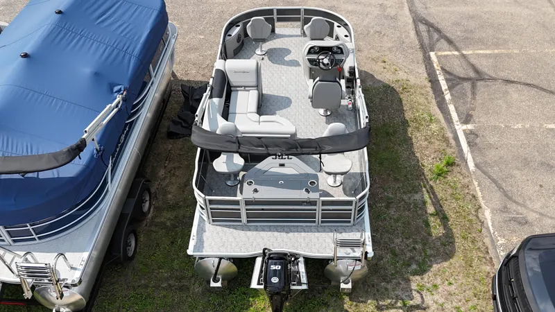 Slide: The Image of 2025 South Bay 220 F pontoon boat, aerial view, parked on grass. - 3