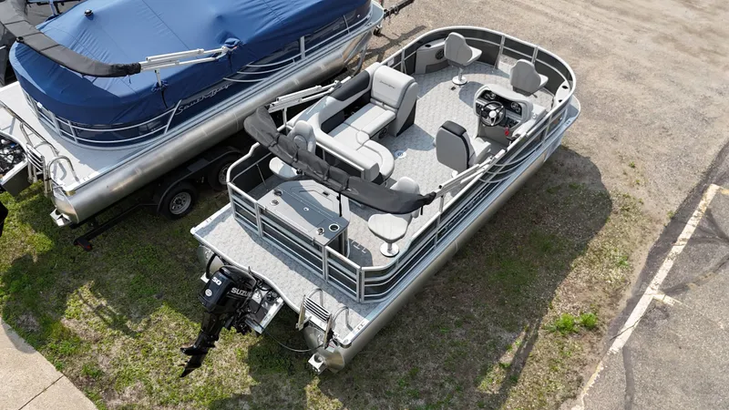 Slide: The Image of 2025 South Bay 220 F pontoon boat, aerial view, docked on grass, with seating and motor visible. - 4
