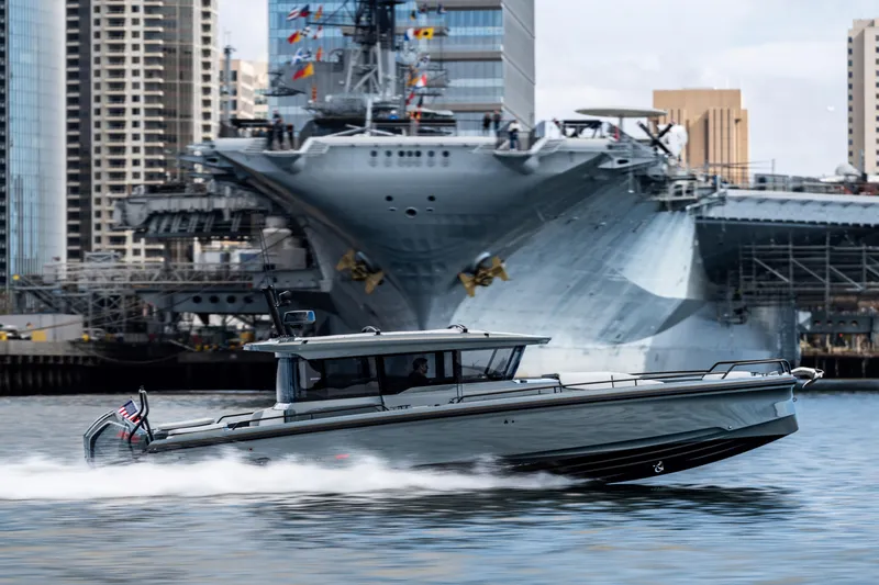 The Image of 2025 BRABUS 1000 Cross Cabin Signature Edition boat cruising near a large battleship. - 0