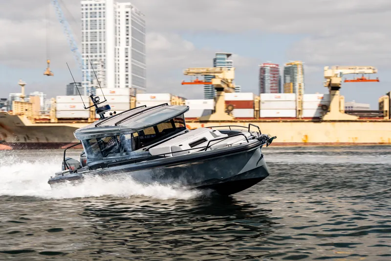 Slide: The Image of BRABUS 1000 Cross Cabin Signature Edition 2025 cruising in an urban harbor setting. - 9