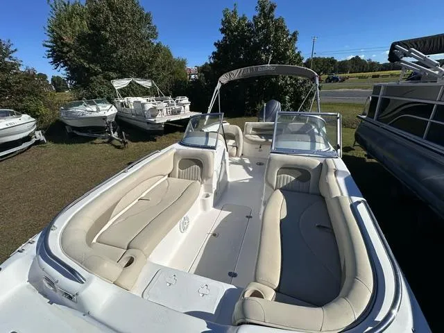 Slide: The Image of 2008 NauticStar 205DC Sport Deck boat with spacious seating and canopy, parked outdoors. - 2