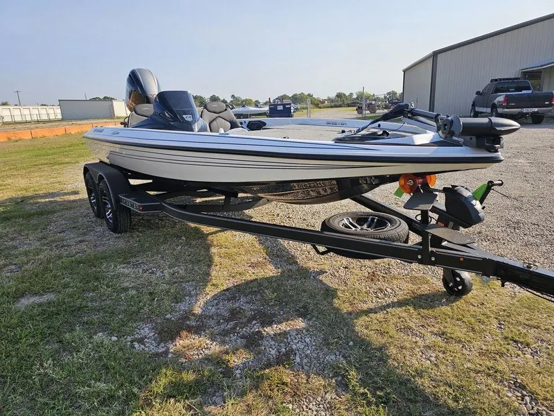 Slide: The Image of 2025 Skeeter ZX150 boat on trailer, parked outdoors on grass and gravel. - 13