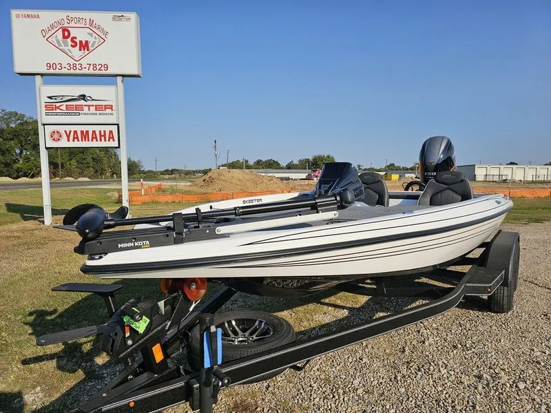 Slide: The Image of 2025 Skeeter ZX150 boat on trailer at dealership with Yamaha sign in background. - 3