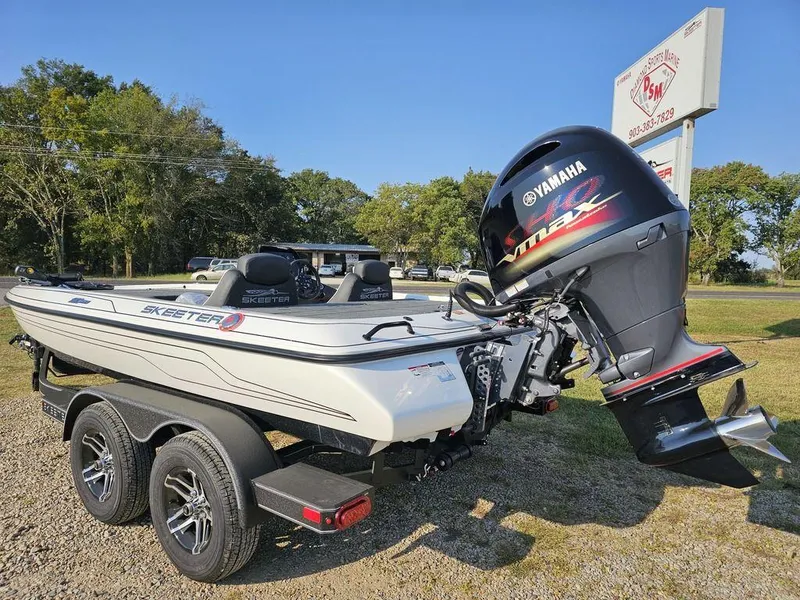 Slide: The Image of 2025 Skeeter ZX150 boat with Yamaha engine on a trailer, parked outdoors. - 7