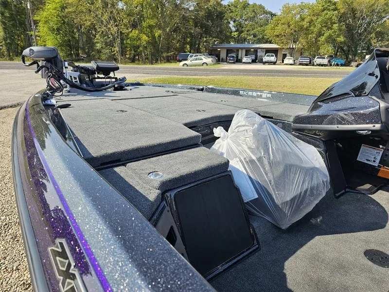 Slide: The Image of 2025 Skeeter ZXR19 boat deck with storage compartments, parked outdoors. - 5