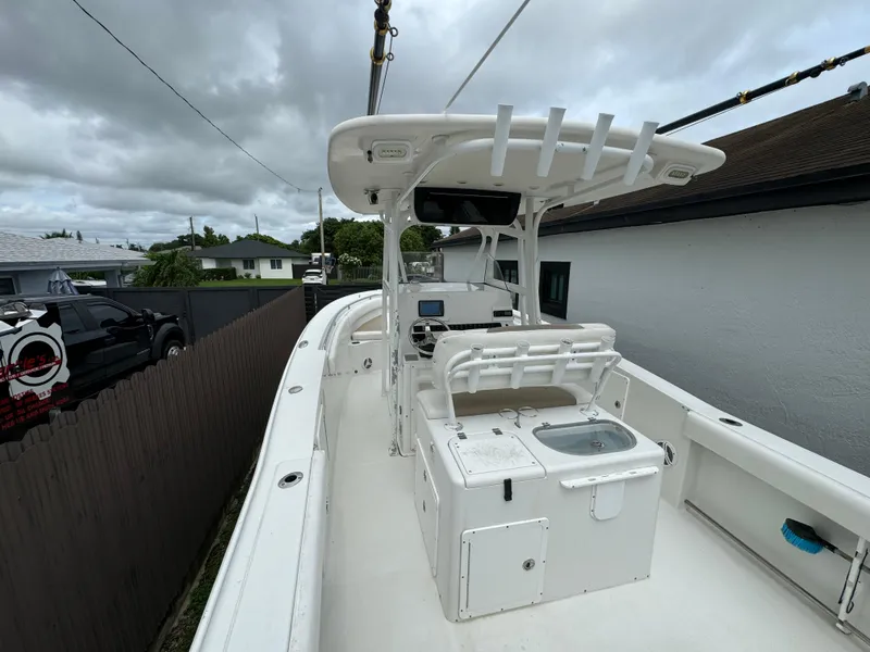 Slide: The Image of 2011 Sea Hunt Gamefish 29 boat with center console and T-top, docked outdoors. - 11