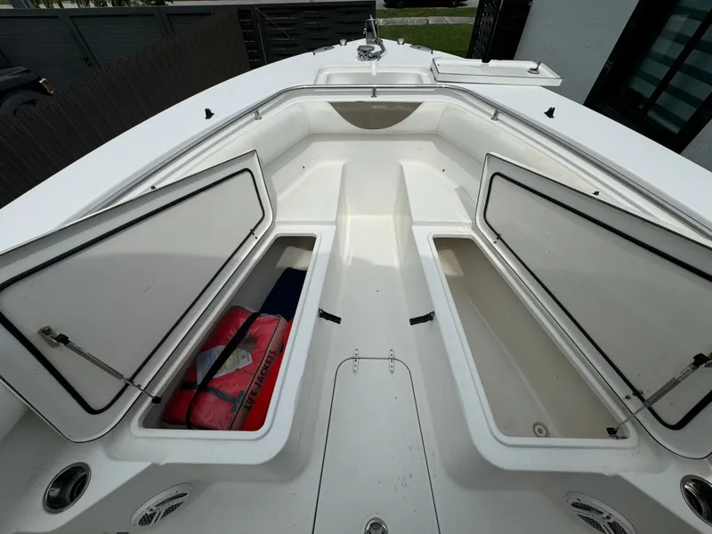 Slide: The Image of 2011 Sea Hunt Gamefish 29 boat with open storage compartments and life jackets. - 31