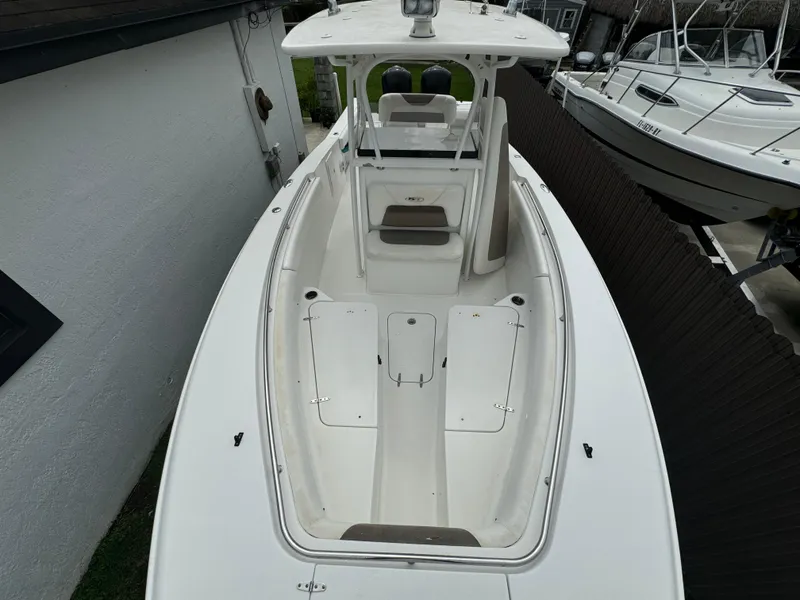 Slide: The Image of 2011 Sea Hunt Gamefish 29 boat, white deck, spacious seating, docked beside another vessel. - 34