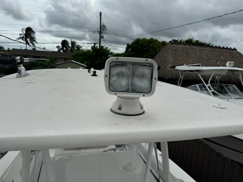 Slide: The Image of 2011 Sea Hunt Gamefish 29 boat with spotlight on deck, cloudy sky background. - 38