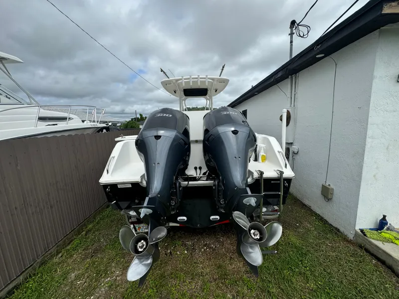 Slide: The Image of 2011 Sea Hunt Gamefish 29 with dual outboard motors, parked beside a building. - 6