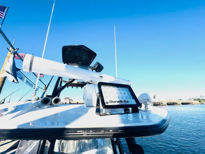 Slide: The Image of 2023 Cape Horn 39T boat interior with wooden deck, docked by a scenic waterfront. - 15