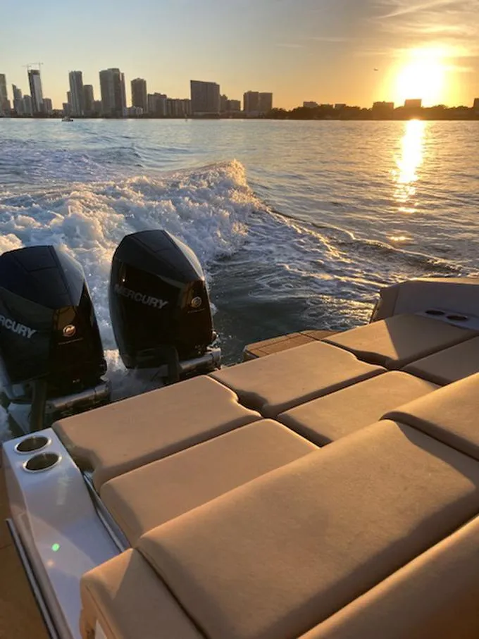 Slide: The Image of 2022 Aviara AV32 OB cruising at sunset with city skyline in background. - 11