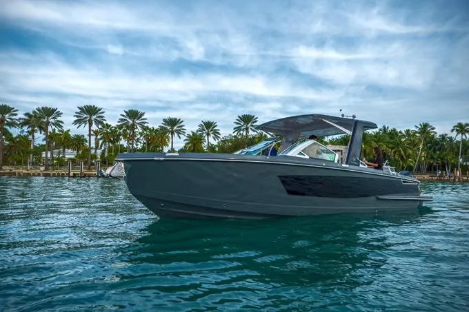 Slide: The Image of 2022 Aviara AV32 OB boat cruising on tropical waters with palm trees in the background. - 15
