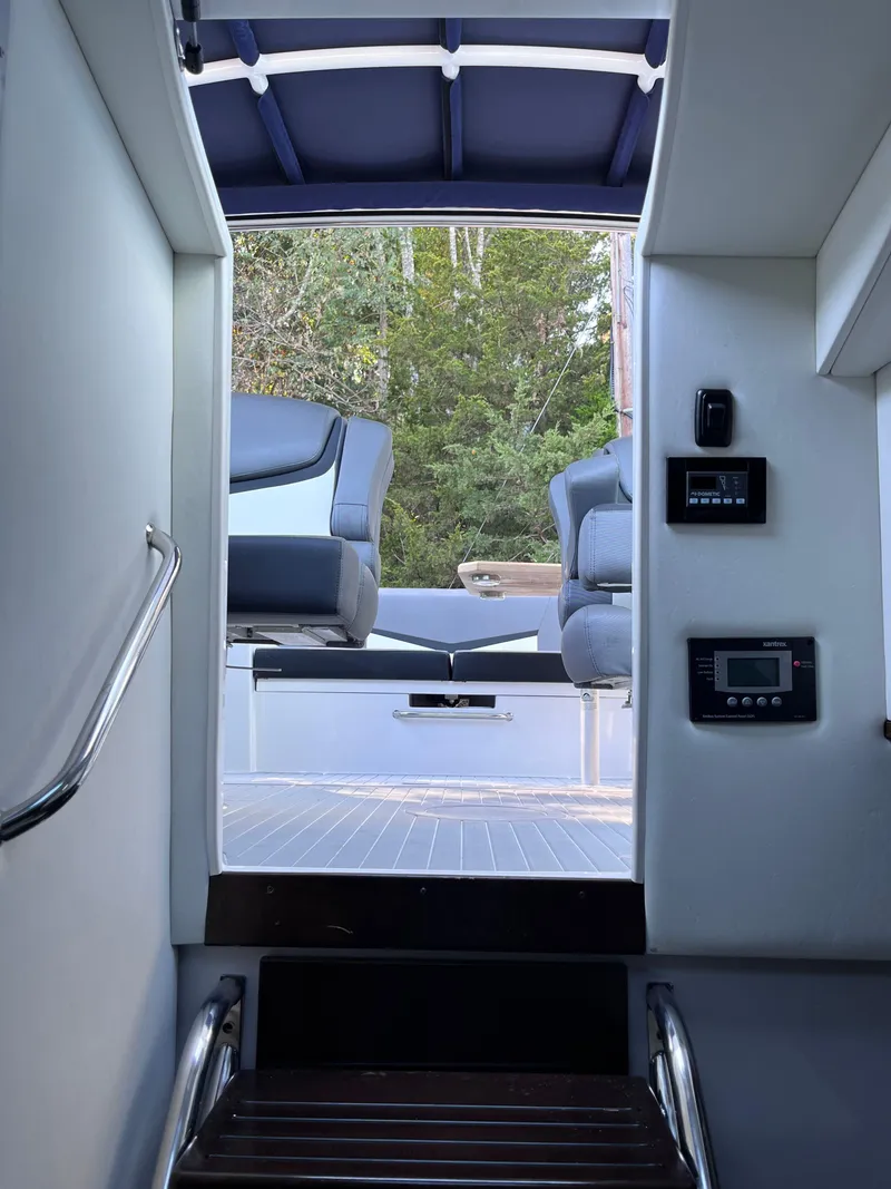 Slide: The Image of Interior view of 2021 Cruisers Yachts 338 CX IO, featuring seating and control panels. - 10