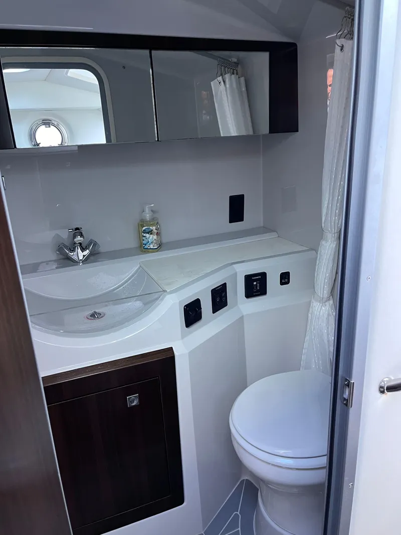 Slide: The Image of 2021 Cruisers Yachts 338 CX IO bathroom with modern fixtures and porthole window. - 11