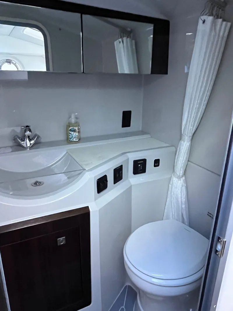 Slide: The Image of 2021 Cruisers Yachts 338 CX IO bathroom with modern fixtures and white decor. - 16