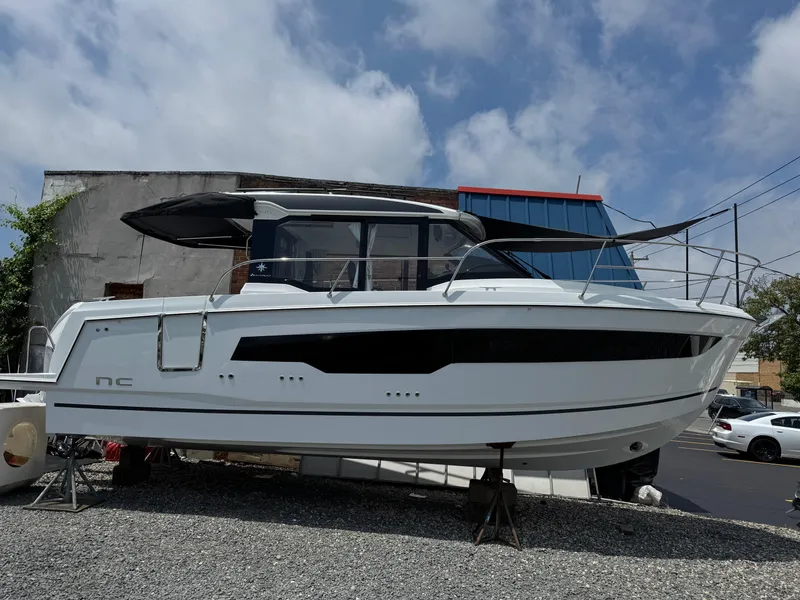 The Image of 2025 Jeanneau NC 895 Series 2 boat displayed outdoors on gravel. - 1