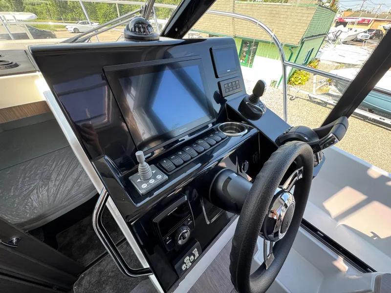 Slide: The Image of 2025 Jeanneau NC 895 Series 2 helm with modern navigation controls and steering wheel. - 12