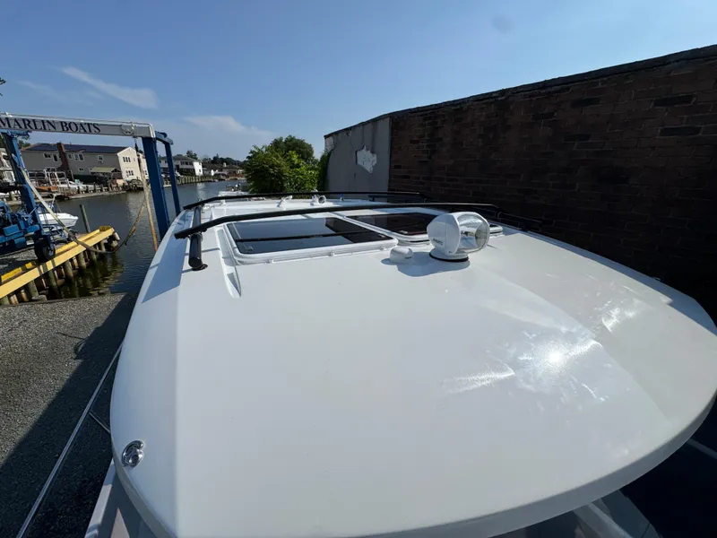 Slide: The Image of 2025 Jeanneau NC 895 Series 2 boat docked near waterfront homes. - 33