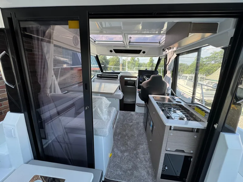 Slide: The Image of Interior view of 2025 Jeanneau NC 895 Series 2 boat, featuring modern kitchen and seating area. - 4