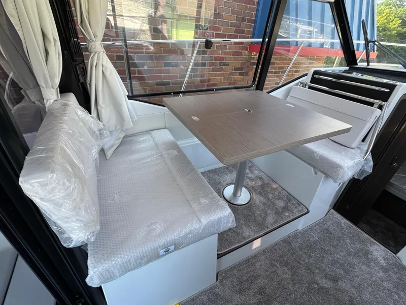 Slide: The Image of Interior of 2025 Jeanneau NC 895 Series 2 boat with dining area and cushioned seating. - 5