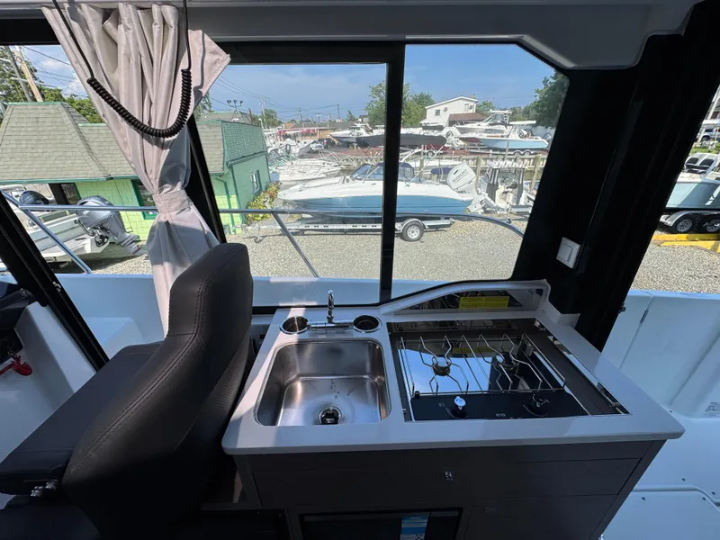 Slide: The Image of Interior of 2025 Jeanneau NC 895 Series 2 boat with kitchenette and window view. - 8