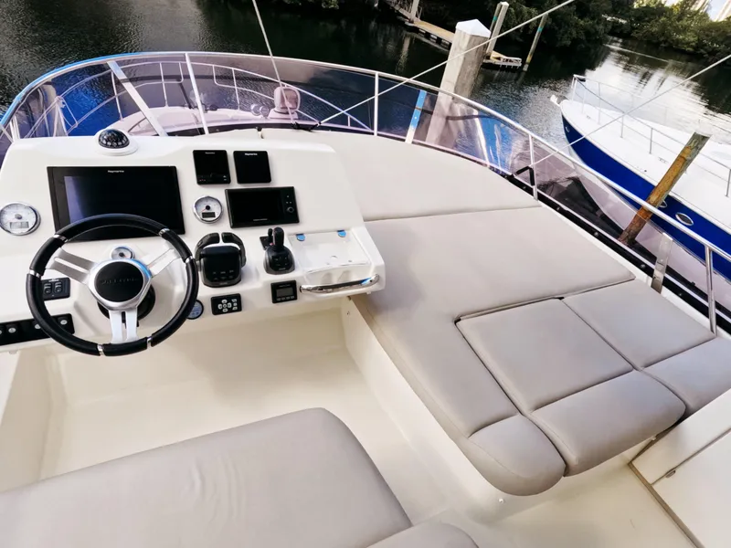 Slide: The Image of Prestige 460 yacht helm with modern controls and seating, docked by the water. - 10
