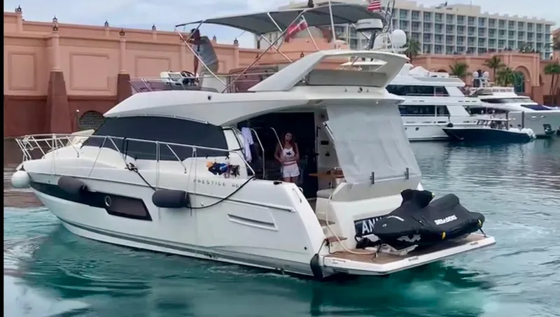 Slide: The Image of Prestige 460 yacht, 2020 model, docked in marina with jet ski on deck. - 2