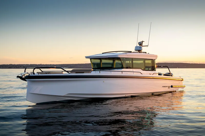 The Image of 2024 Axopar 37 XC BRABUS Trim Wet Bar on serene water at sunset. - 0