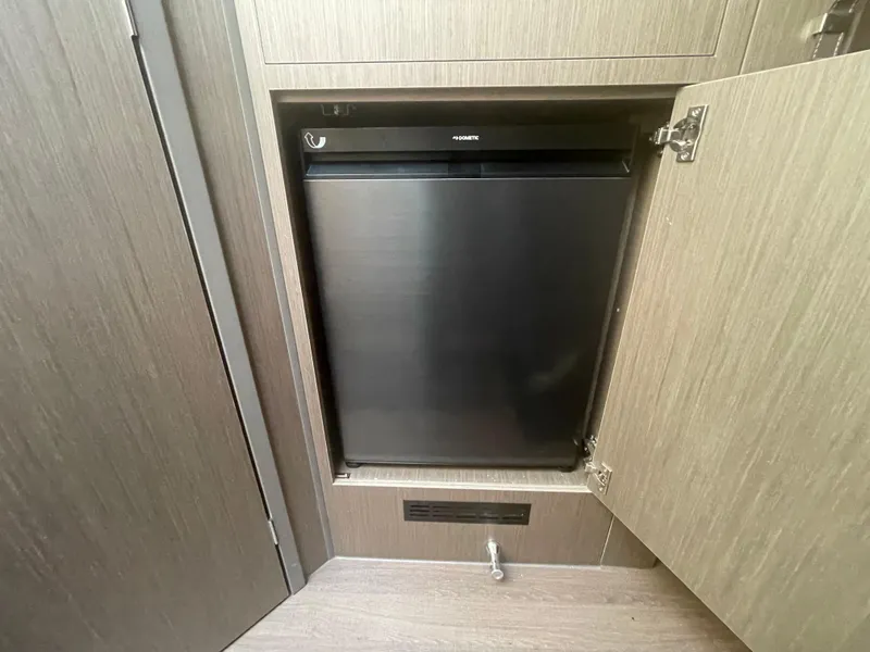 Slide: The Image of 2024 Beneteau Gran Turismo 32 interior with built-in compact refrigerator. - 13