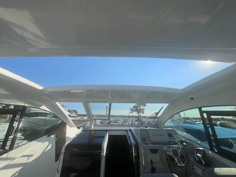 Slide: The Image of 2024 Beneteau Gran Turismo 32 cockpit with panoramic roof and modern controls. - 2