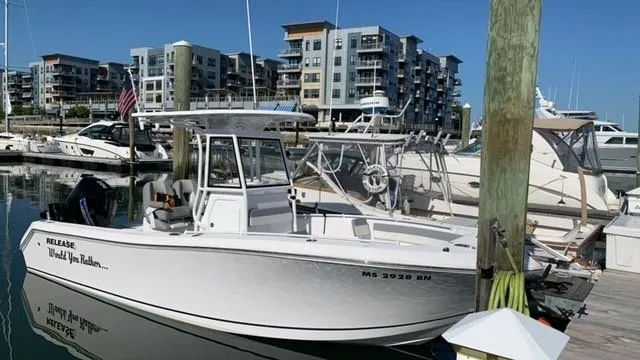 Slide: The Image of White 2021 Release 240RX boat docked in marina with modern buildings in background. - 13