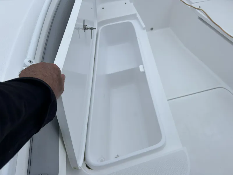 Slide: The Image of Open storage compartment on 2021 Release 240RX boat. - 16