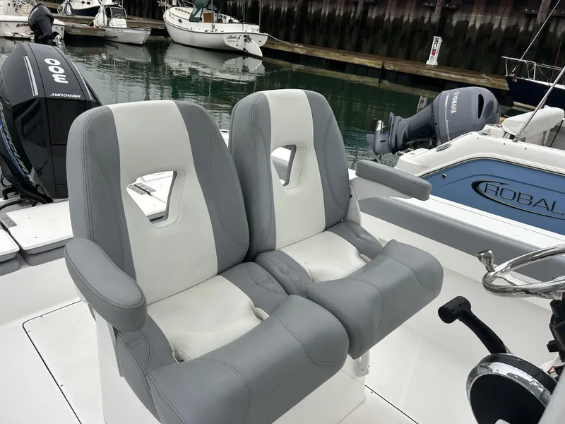 Slide: The Image of Dual gray and white boat seats on a 2021 Release 240RX, docked with other boats. - 3