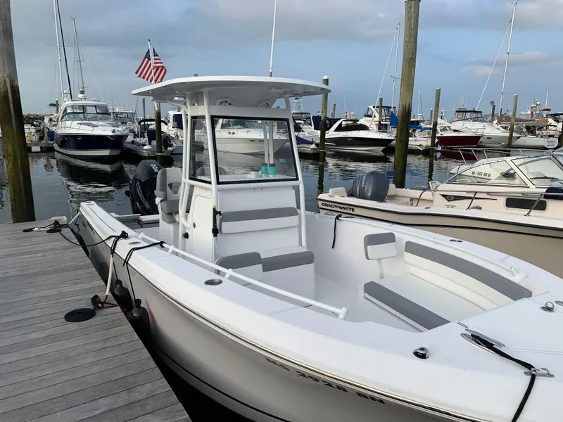 Slide: The Image of A 2021 Release 240RX boat docked at a marina with other vessels. - 5