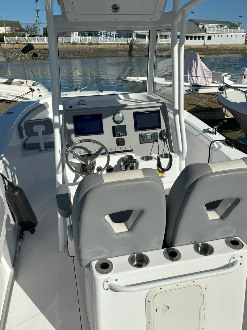 Slide: The Image of 2021 Release 240RX boat interior with dual seats and modern dashboard at marina. - 9