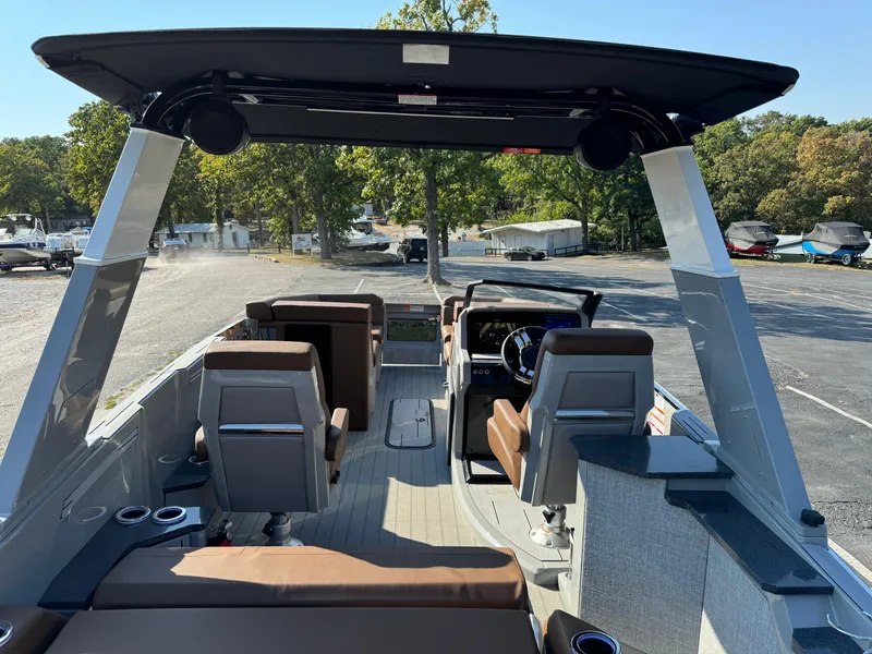 Slide: The Image of 2025 Balise Helix 24L boat interior with seating and steering wheel, parked outdoors. - 10