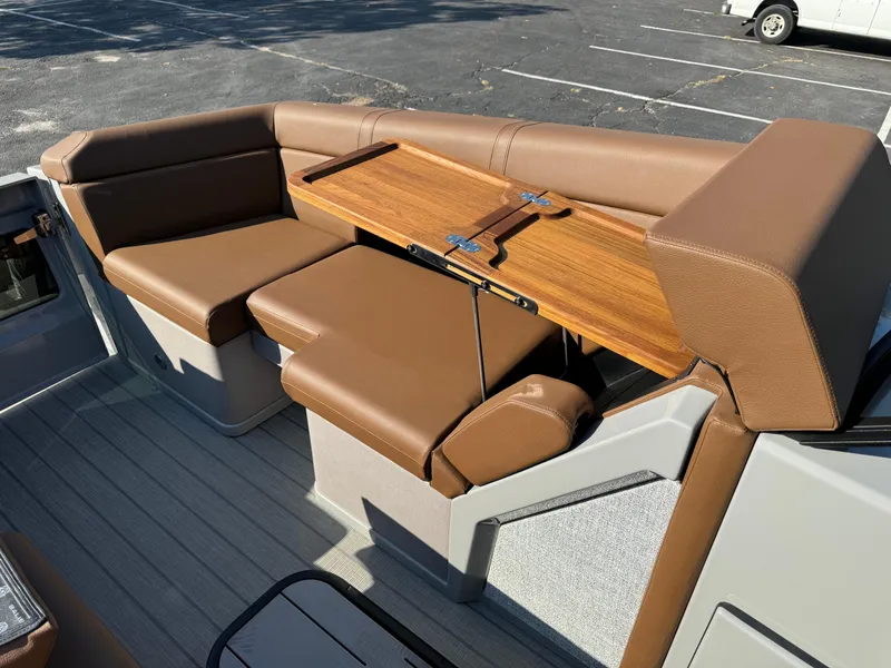 Slide: The Image of Balise Helix 24L 2025 boat interior with brown leather seating and wooden table. - 18
