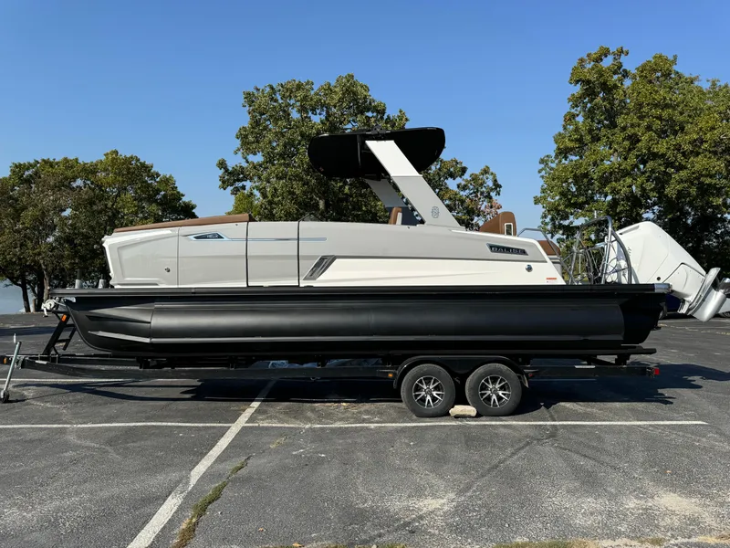 Slide: The Image of 2025 Balise Helix 24L boat on trailer, parked outdoors. - 2
