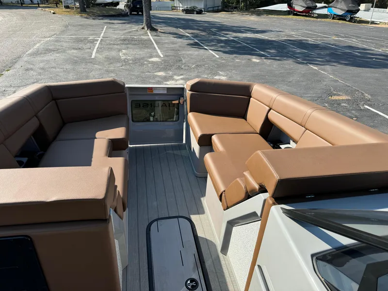 Slide: The Image of 2025 Balise Helix 24L boat interior with brown seating in a parking lot. - 26