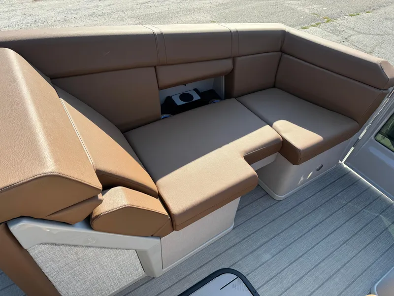 Slide: The Image of Balise Helix 24L 2025 boat seating area with brown cushions and storage compartment. - 7