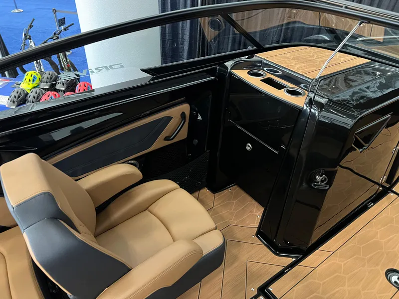 Slide: The Image of 2025 Yamaha Boats 255XD interior with tan seats and sleek black dashboard. - 11