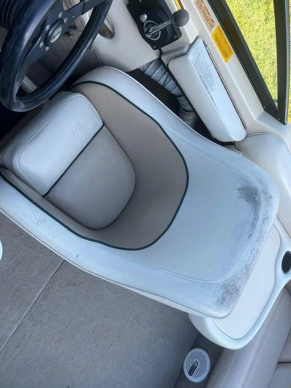 Slide: The Image of 1999 Malibu Sunsetter VLX boat interior with worn white seat and steering wheel. - 10