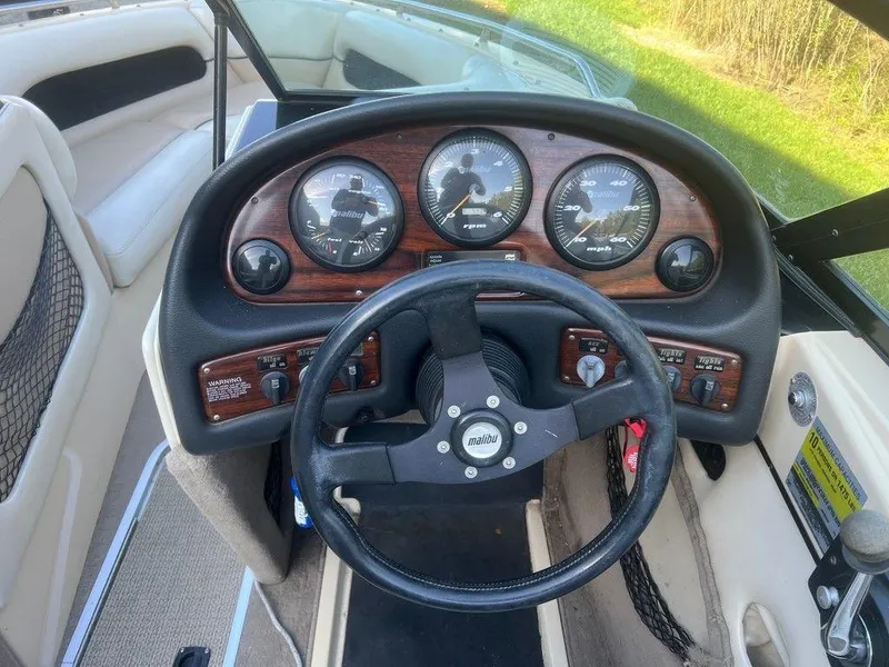 Slide: The Image of 1999 Malibu Sunsetter VLX boat dashboard with steering wheel and gauges. - 6