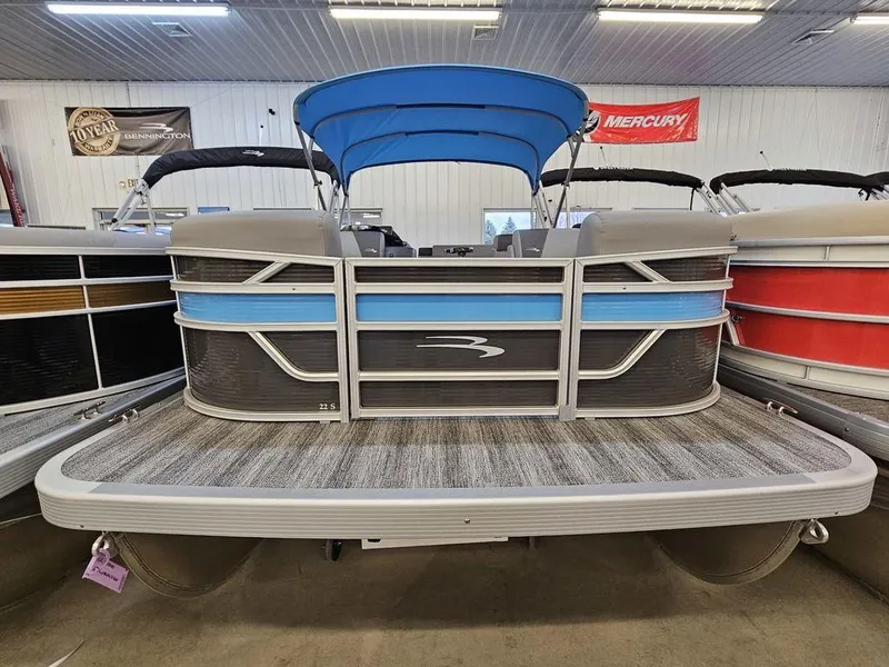 Slide: The Image of 2025 Bennington 22SLJ pontoon boat with blue accents in a showroom. - 1